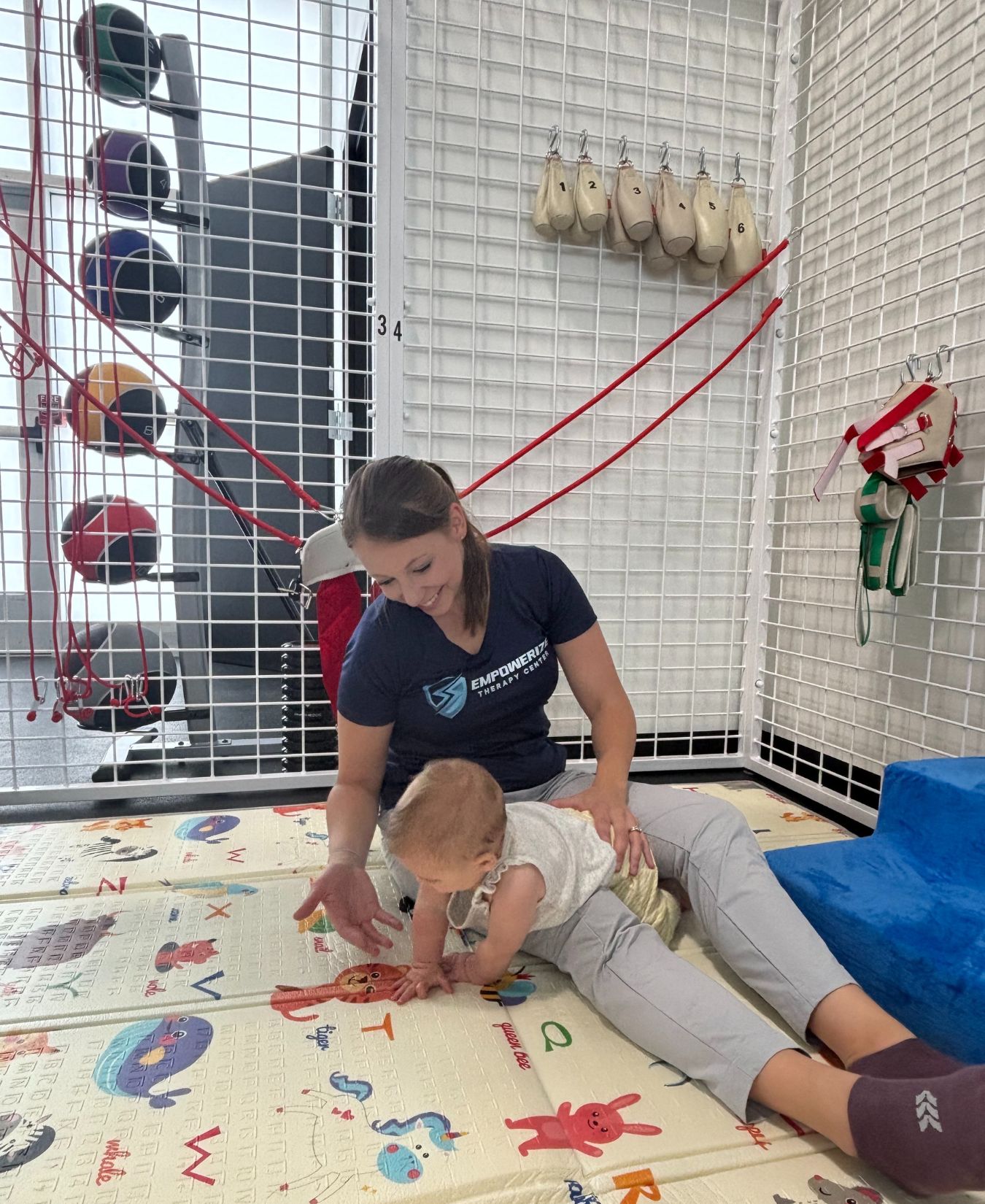 Physical therapist working with an infant on a play mat