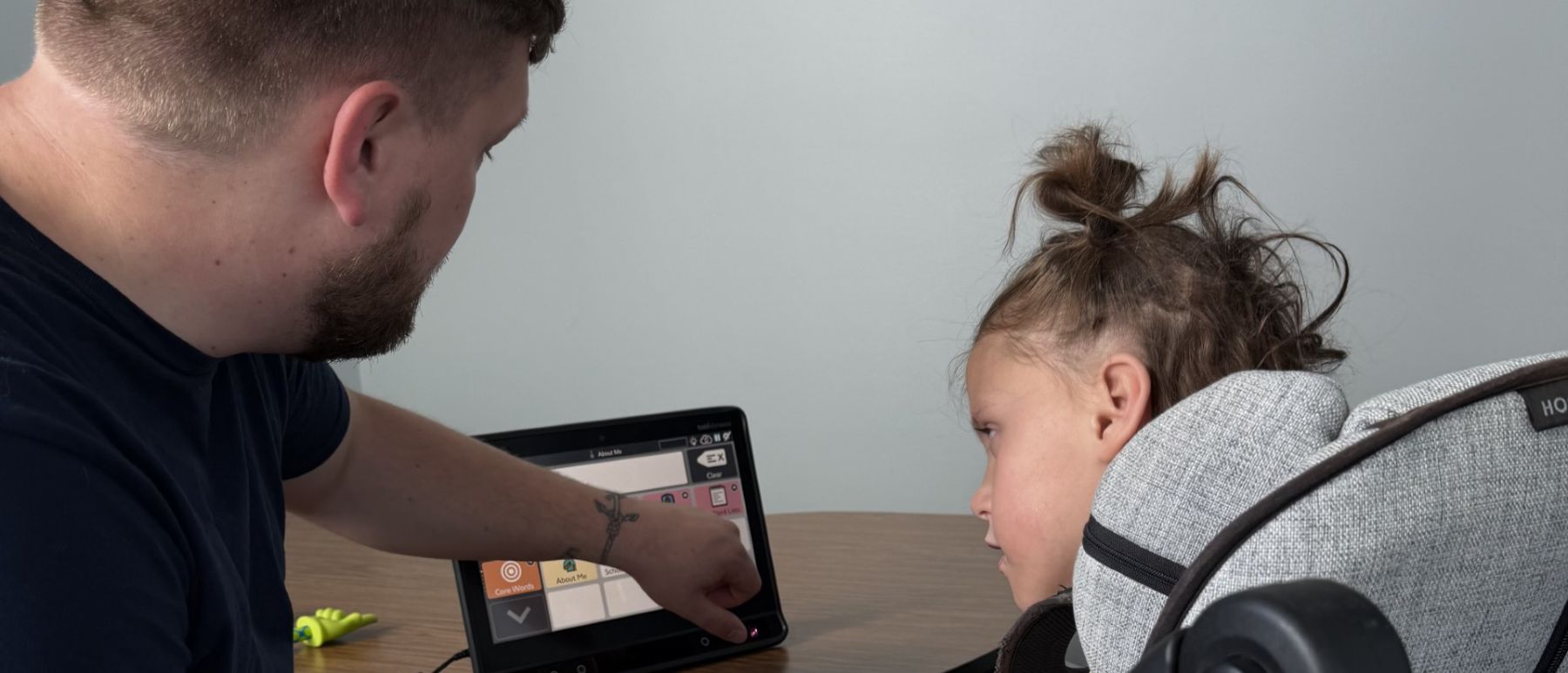 Speech-language pathologist and child using a communication device